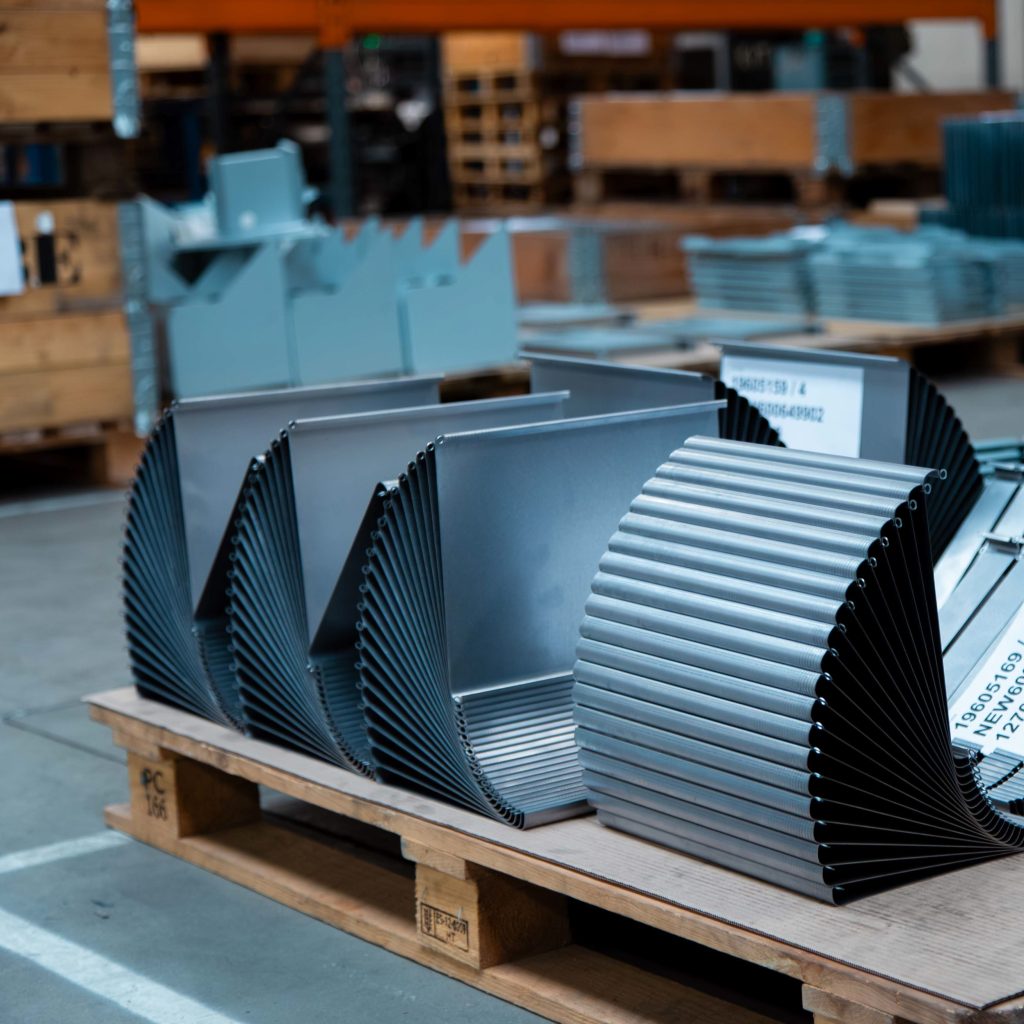 Gestapelde gebogen plaatwerk onderdelen op pallet na CNC kantwerk in productieomgeving