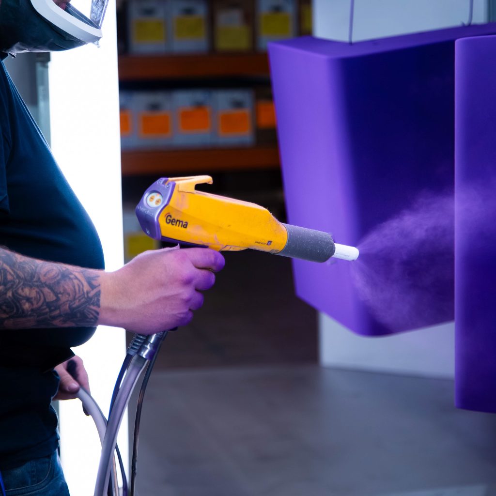 Poedercoaten van metalen onderdeel met elektrostatisch spuitpistool in coatinglijn